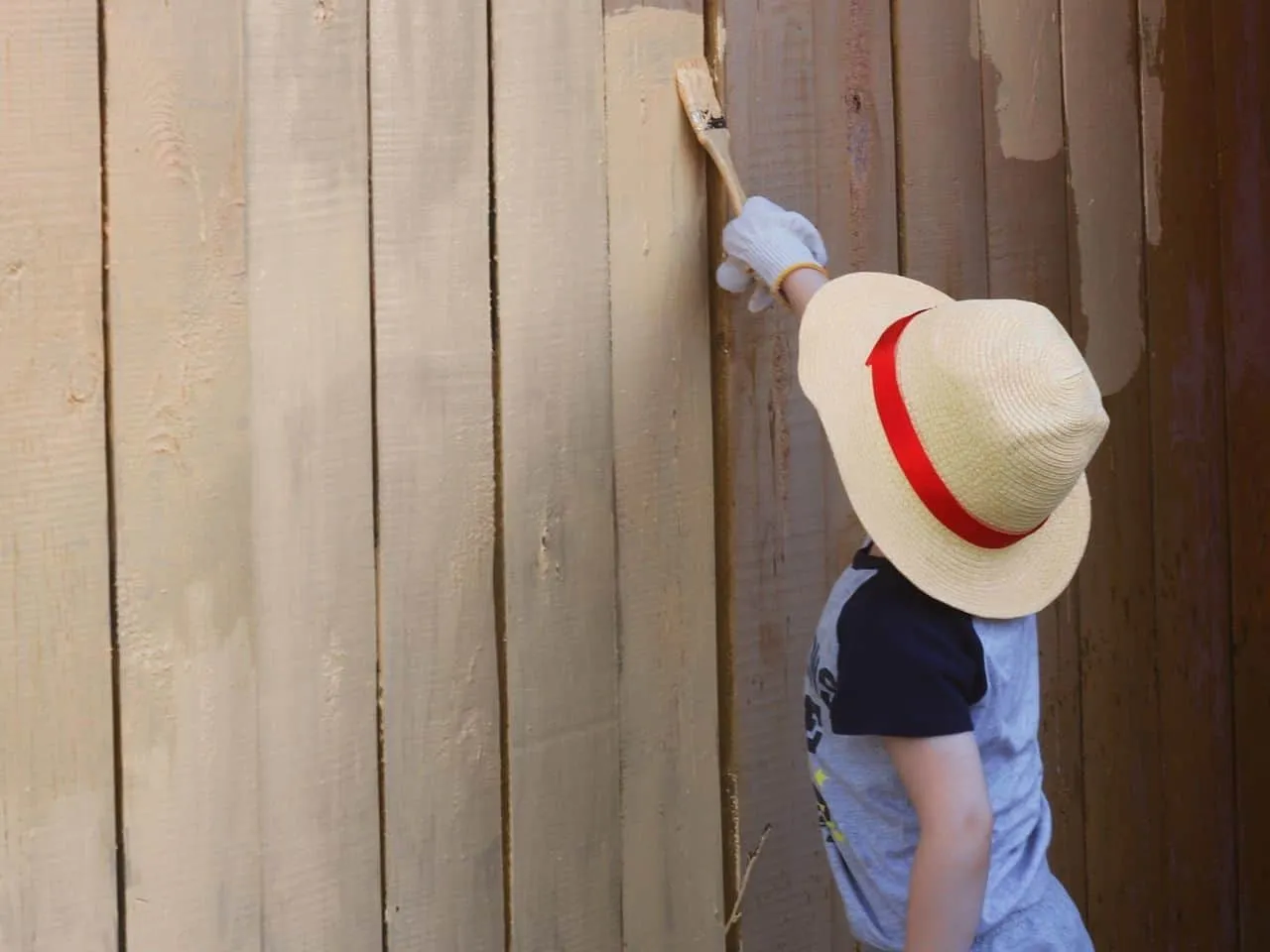 Child painting a fence