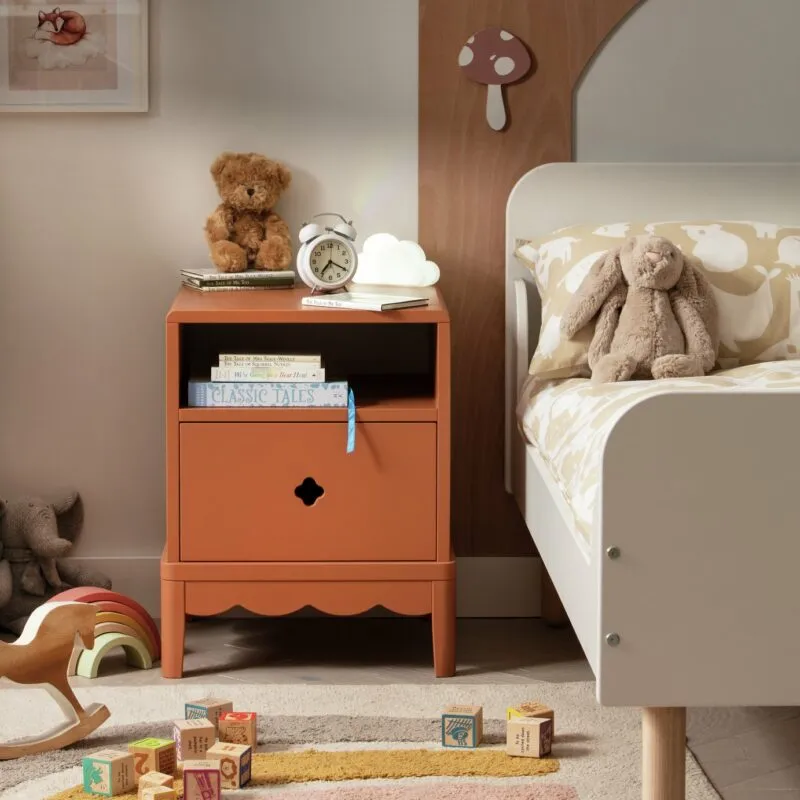 Rust coloured bedside table with scalloped detailing