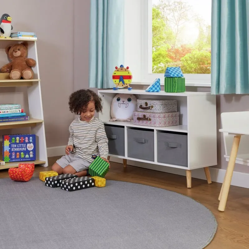 Kid's white storage unit with open shelf and a set of 3 grey fabric storage boxes